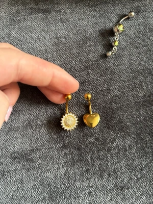 Två guldiga piercingar - Jättefina navelpiercingar, nytt skick på båda🩷hjärtat är ifrån shein och den andra är från en marknad i grekland!