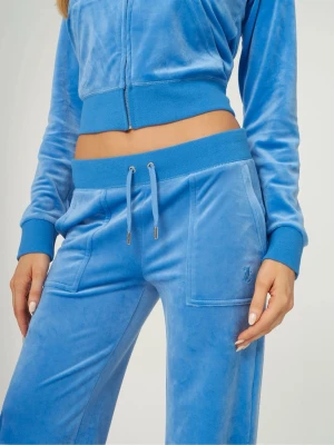 Blå velour loungewear-set Juicy Couture - Mysigt loungewear-set i blå velour från Juicy Couture. Setet består av en zip-up hoodie med bred mudd och matchande byxor med dragsko i midjan och stora fickor. Perfekt för chill dagar hemma eller när du vill vara extra bekväm.