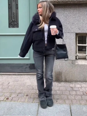 Mörkblå teddyjacka från Gina Tricot - Säljer en mörkblå teddyjacka från Gina Tricot med fluffig fuskpäls på kragen och två stora bröstfickor med knappar. Jackan har en mysig och trendig look, perfekt för kalla dagar.