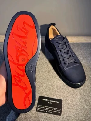 Marinblå sneakers från Louboutin - Snygga marinblå sneakers från Christian Louboutin med klassisk röd sula och diskret logga. Skorna har rund tå, svarta skosnören och ovandel i textil. Insidan är beige och sulan är i gummi med den ikoniska röda färgen.