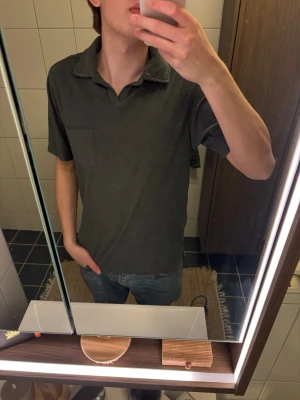 Mörkgrå frotté pikétröja med bröstficka - Mörkgrå frotté pikétröja från John Henric, size M. Jag är 187cm och 75kg