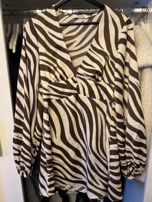Klänning från nakd - Zebra mönstrad klänning ifrån nakd, sitter jätte smickrande på kroppen och har fina ärmar! Använd fåtal gånger. Skriv vid frågor💗