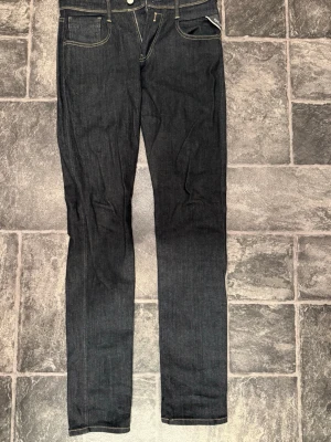 Replay anbass jeans slim fit ( W29 L32) - Säljer ett par stilrena Replay Anbass jeans i mörkblå tvätt. Modellen är slim fit och ger en smal, modern passform som sitter bekvämt. Klassiska Replay-detaljer på bakfickorna samt originalpatch baktill.  Storlek: W29 L32. Skick: Mycket fint skick, inga defekter eller slitningar.  Passar lika bra till vardag som till en mer uppklädd stil.