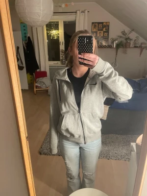 Grå zip-hoodie från Nike - Jättefin och skön hoodie från Nike. Kommer tyvärr inte till användning. Passar både en mer vardaglig men även sportig look