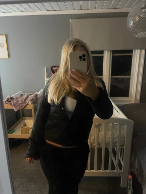 Svart pufferjacka från Gina Tricot - Säljer en svart pufferjacka från Gina Tricot med rund halsringning och knäppning framtill. Jackan har quiltad design och är lätt vadderad, perfekt för kalla dagar. Enkel och stilren modell som är lätt att matcha med olika outfits.