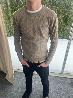 Beige kabelstickad tröja Morris  - Säljer en beige kabelstickad tröja från Morris. Riktigt bra skick. Storlek M. Personen på bilden är 183 cm lång.