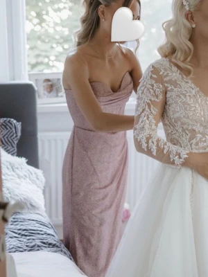 Glittrig rosa långklänning - Köpt på Jolie Bridal våren 2024 och endast använd vid ett tillfälle på bröllop. Det går även att justera så att man har band som håller upp vid brösten. Perfekt för speciella tillfällen och högtider.