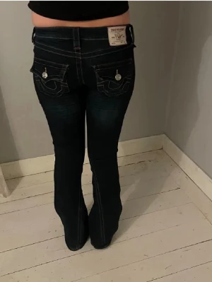 Mörkblå bootcut jeans True Religion - True religion jeans i storlek w25 passar mig som är 169cm. Endast använda max 5 gånger, inga defekter. Lowwaist
