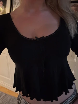 Svart topp med volang - Säljer denna svarta topp ifrån Gina i storlek M(liten i storleken). Jätte söt topp som ej säljs längre!
