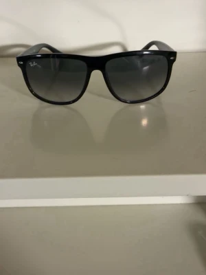 Svarta Ray-Ban 4147 (boyfriends) solglasögon - Snygga svarta solglasögon från Ray-Ban med klassisk wayfarer-form. Bågarna är i blank svart plast och glasen är mörka med en lätt toning. Perfekta för soliga dagar och ger en cool vibe till din outfit. (4147) (boyfriend)