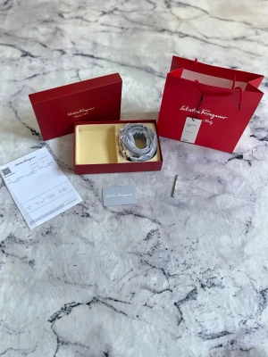 Salvatore Ferragamo Skärp - VIKTIGT! Bältet är verifierat av vinted av att vara äkta, köpt i ett shopping center i Hong Kong. Ett mycket fin aldrig använt skärp ifrån Salvatore Ferragamo. Bältet köptes som present men kom aldrig till någon användning.                  Om du har några funderingar mm så är det bara att höra av sig!