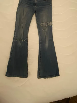 Blå bootcut jeans utan midja - Säljer ett par blå bootcut jeans utan midja. Passar dig om du är 160-165