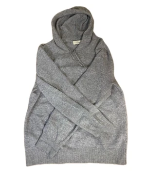 Grå cashmere hoodie från Sayless - Mjuk och stilren grå hoodie från Sayless i lyxig cashmere. Klassisk modell med huva och ribbade muddar vid ärmslut och nederkant. Perfekt för dig som gillar en enkel men exklusiv look.