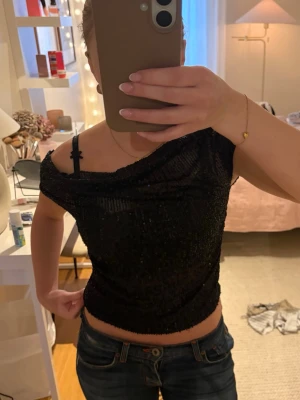 Svart glittrig offshoulder topp - Snygg svart topp med glittriga paljetter och offshoulder-design. Endast använd en gång! Pris kan alltid diskuteras💞