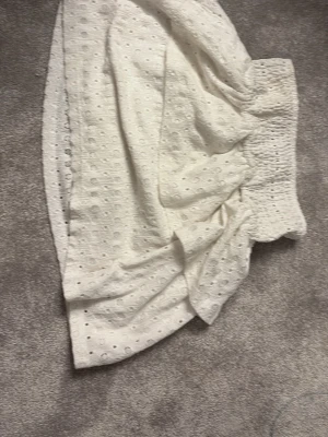 Vit ihålig kjol - Säljer denna mönstrade somriga benvita volang-kjol från pieces! Använd ett fåtal gånger men är som ny.