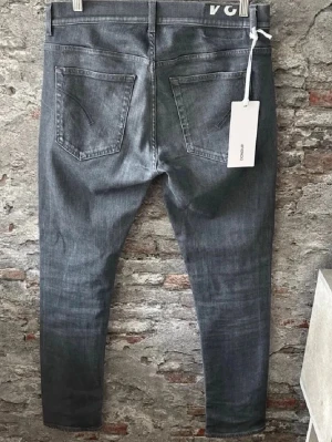 Dondup jeans - Snygga grå jeans från Boohooman med smal passform och klassisk femficksdesign. Jeansen har en modern, något tvättad look och är tillverkade i ett mjukt bomullsmaterial med stretch för extra komfort. Perfekta för dig som gillar stilrena och enkla jeans. Ingen lapp kvar