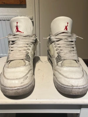 Jordan 4 Oreo - Säljer ett par Air Jordan 4 Retro Oreo sneakers med meshpaneler och detaljer i läder. Skorna har den klassiska Jumpman-loggan i rött på plösen och grå inslag på sulan. Snygg siluett med lågt skaft och ikoniska plastdetaljer på sidorna. Ingen sula följer med tyvärr 