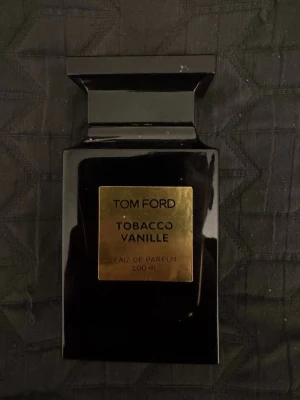 Tom Ford Tobacco Vanille EdP 100ml - Tom Ford Tobacco Vanille Eau de Parfum i en elegant svart glasflaska med guldetikett. Flaskan rymmer 100 ml och har en lyxig, stilren design som känns exklusiv och modern. Perfekt för dig som gillar varma, kryddiga dofter med inslag av tobak och vanilj. Knappast använt den, ny pris på ca 2400kr. Pris kan diskuteras! Hör av er!