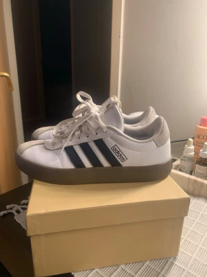 Adidas VL court - Adidas VL court i storlek 38. Skorna har en brun gummisula och är låga och platta i modellen. Säljes i skicket på bilden. Inköpt i sommras.