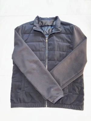 Mörkblå cardigan jacka - Stilren mörkblå cardigan med quiltad framsida och släta ärmar. Jackan har hög krage och hel dragkedja framtill. Perfekt för kyligare dagar och enkel att matcha med olika outfits. Jackan är från Zara men saknar lappar. Storlek S/M. Skick 8/10.