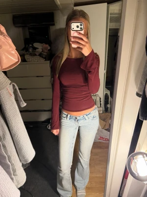 Ginatricot långärmad topp med utsvängda ba ärmar - Säljer en bordeauxfärgad långärmad topp med figurnära passform och trendiga utsvängda ärmslut. Använd 1 gång och säljer för tycker tyvärr inte färgen passar på mig❤️Toppen är i ett mjukt, stretchigt material och har en snygg croppad längd. Perfekt att styla med jeans eller kjol.
