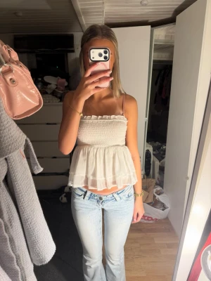 Vit volangig linnetopp med smock - Söt vit linnetopp med smock över bysten och volangig nederdel som är från Nelly. Jätte söt till sommaren❤️  Perfekt för varma dagar och enkel att styla med jeans eller kjol.