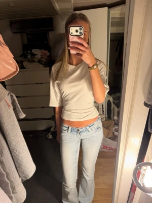 Vit croppad topp med knyt i ryggen - Trendig vit croppad topp med korta ärmar och snygg knytning i ryggen som är från Nelly❤️. Jätte bra skick och använd 4-5 gånger❤️ Toppen har en enkel, clean look framtill och öppen rygg med breda band som knyts. Perfekt till jeans eller kjol för en cool och avslappnad stil. Pris kan diskuteras❤️❤️