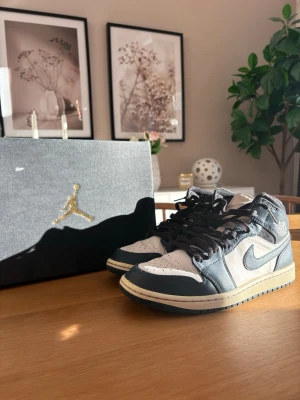 Nike Air Jordan 1 Retro High OG navy blue - Snygga Nike Air Jordan 1 Retro High OG sneakers i navy blue och vitt läder med klassisk swoosh på sidan. Skorna har högt skaft, svarta skosnören och beige mellansula för en retro vibe. Perfekta för dig som gillar streetwear och ikoniska modeller.