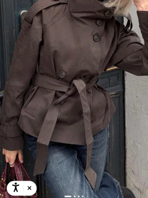Kort brun trenchcoat Bershka  - Snygg kort trenchcoat i mörkbrunt från Bershka i storlek M.