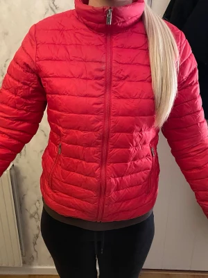 Röd pufferjacka med dragkedja från peak performance  - röd pufferjacka från peak performance i bra skick. säljes då jag ej använder jackan längre. 