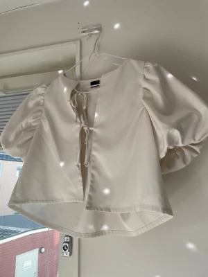 Vit puffärmsblus med knytband - Trendig vit blus med puffiga korta ärmar och två knytband framtill!🤍 Köpt från gina tricot, verkar ej finnas kvar på hemsidan. Storlek xs! 🤍