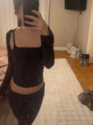 Skön långärmad topp - Trendig mörkgrå topp med långa ärmar. Toppen har en tight passform och fyrkantig urringning som ger en modern look. Materialet är väldigt stretchigt och mjukt ut.