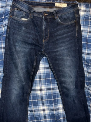 Mörkblå jeans slim fit - Säljer ett par klassiska mörkblå jeans.  Jeansen har normal passform, fem fickor och snygga kontrastsömmar. Perfekta till vardagslooken och passar till det mesta. Materialet är mjukt och bekvämt bomullstyg.