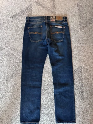 Blå jeans från Nudie Jeans - Säljer nu dessa nudie jeans i modellen troubled sea. Storlek är W 31 (men passar 30) och L 30. Nypris 1299 kr mitt pris 559kr. Priset kan diskuteras vid snabb affär. ( på bilden ser man att lapparna är kvar men det är dem inte längre). 