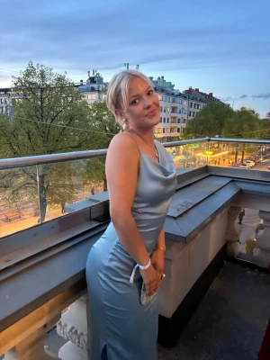 Ljusblå lång satinklänning - Fin ljusblå långklänning i satin från Adoore. Klänningen har en slits på sidan och figurnära passform som ger en snygg siluett. Perfekt för bal eller student. Använd en gång för min egna bal:) nypris 1595kr