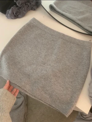 Grå stickad kortkjol - En enkel och stilren grå stickad kortkjol med ribbad kant upptill och nedtill. 