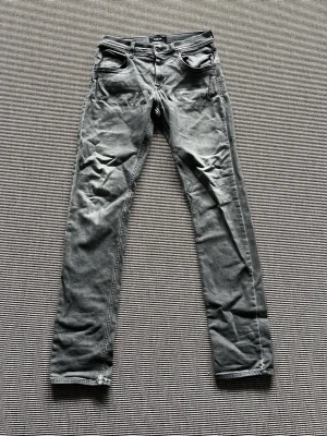 Grå slim fit jeans från Replay - Snygga grå slim fit jeans från Replay  med klassisk femficksdesign och knappgylf. Jeansen har en tvättad look och raka ben. Perfekta för dig som gillar en stilren och avslappnad vibe. OBS! Dem har två hål vid bakfickorna ca 2cm