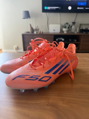 Adidas F50 orange/blå fotbollsskor - Säljer ett par Adidas F50 fotbollsskor i ett grymt skick, använda typ 2 träningar. Strlk 43 och 1/3. Det är ag dobbar!