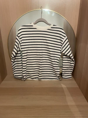 Randig långärmad topp från Zara - Säljer en klassisk långärmad topp från Zara i svart och vitt med tidlösa horisontella ränders storlek 134-140. Tröjan har rund halsringning och är gjord i mjuk bomull, perfekt för en avslappnad och stilren look.skriv för fler bilder,pris kan diskuteras!💗(säljer även en i mörkblått med vita ränder)
