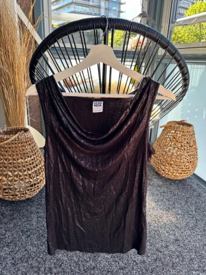 Glittrig topp tajt topp med waterfall ringning  - Svart glittrig topp med waterfallringning.