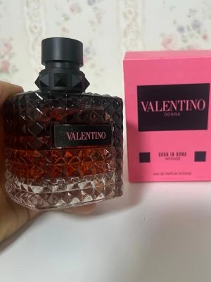 Valentino Donna Born In Roma Intense - Lyxig parfym från Valentino i serien Donna Born In Roma Intense. Flaskan är mörkrosa till svart med ett coolt nitat mönster och svart lock. Kommer i en snygg rosa kartong med svart text. Perfekt för dig som gillar exklusiva dofter och snygg design.