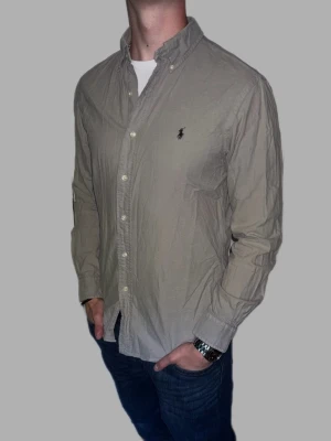 Grå skjorta från Ralph Lauren - 🔹 Märke: Ralph Lauren 🔹 Modell: Skjorta 🔹 Storlek: M 🔹 Färg: Grå 🔹 Skick: Väldigt fint skick 🔹 Passform: Slim 🔹 Pris: 349kr  ✅ 100% äkta ✅ Snabb frakt ✅ Fler bilder/video finns vid intresse ✅ Stilren och lättmatchad