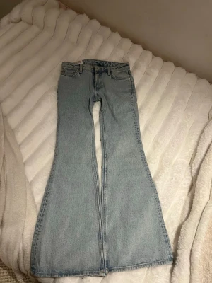Ljusblå utsvängda jeans Weekday - Säljer ett par ljusblå jeans från Weekday, modell Flame. Jeansen har låg midja och utsvängda ben. Helt slutsåld. Otroligt fina lågmidjade, säljer då dom tyvärr är för små. Endast testade en gång. Midjemått 38cm gren 20cm innerbenslängd 80cm