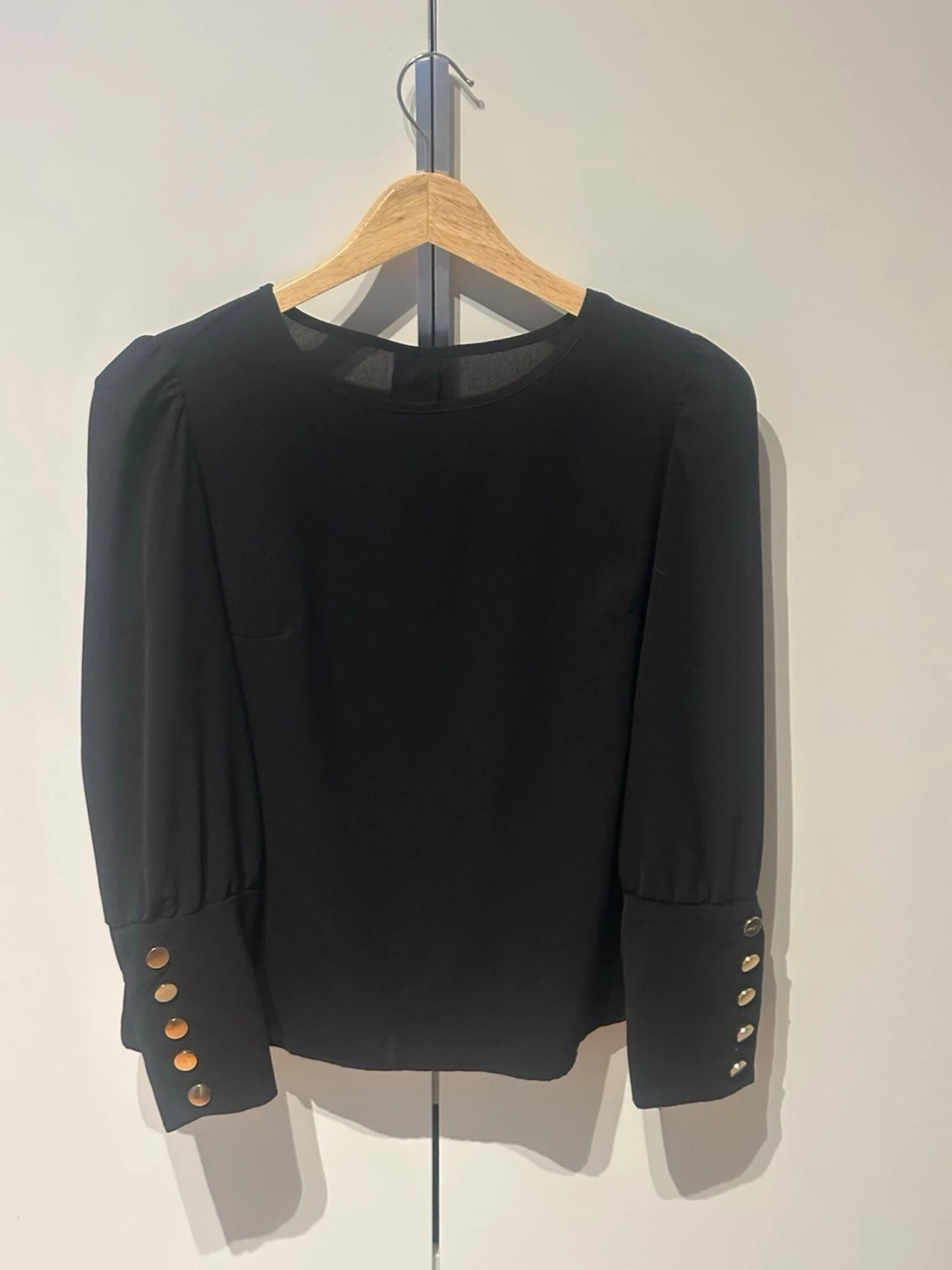 Svart blus med guldknappar