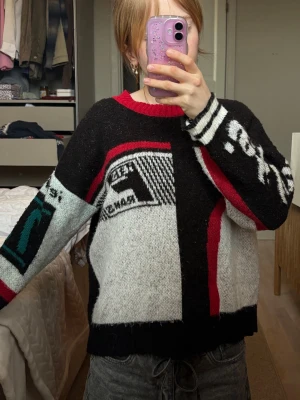 Grafisk stickad tröja med mönster- UO - Stickad tröja med grafiskt mönster i svart, vitt, rött och grönt. Mjukt och skönt material. Köpt på Urban Outfitters!