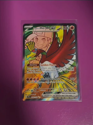 Pokémonkort Ethan's Ho-oh EX - Säljer ett samlarkort från Pokémon, Ethan's Ho-oh EX med holografisk yta. Kortet har färgstark design med Ethan och Ho-oh i rött, gult och grönt. Kortet har 230 HP och attacker som Golden Flame och Shining Feathers. Perfekt för samlare eller Pokémonfans.