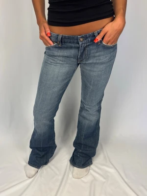 Lågmidjade Jeans - 7 for all mankind Jeans | Färg: Blå/grå | Size: 30 | Fint skick, inga defekter | Modellen på bilderna är 168cm lång och väger 60kg | Mått: Ytterbenslängd: 105cm. Midjebredd: 42cm. Lårbredd: 26cm. Fotöppning: 25cm. Kontakta mig vid fler frågor eller funderingar!