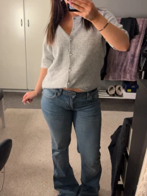 Blå bootcut jeans med fickdetaljer - Snygga blå bootcut jeans med låg midja. Jeansen har en lätt tvättad look och snygga fickor.
