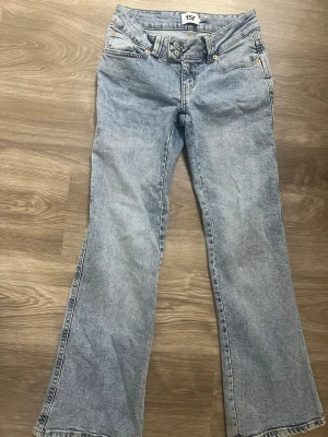 Ljusblå bootcut jeans från 157 - Säljer ett par ljusblå bootcut jeans från 157 med klassisk femficksdesign och dragkedja. Jeansen har utsvängda ben och är tillverkade i mjukt denimtyg. Perfekta för dig som gillar retrostil och vill ha ett par bekväma jeans med snygg passform. Storlek xs i SHORT lenght, använda bara 1 gång (priset går att diskutera)