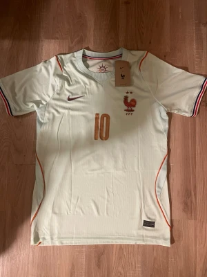 Frankrike Mbappé VM-2026 Fotbollströja - Ljusgrön Frankrike fotbollströja med nummer 10 och Mbappe på ryggen. Tröjan har korta ärmar och är tillverkad i ett lätt, ventilerande material. Perfekt för fotbollsträning eller att bara bära som supporter. HELT NY